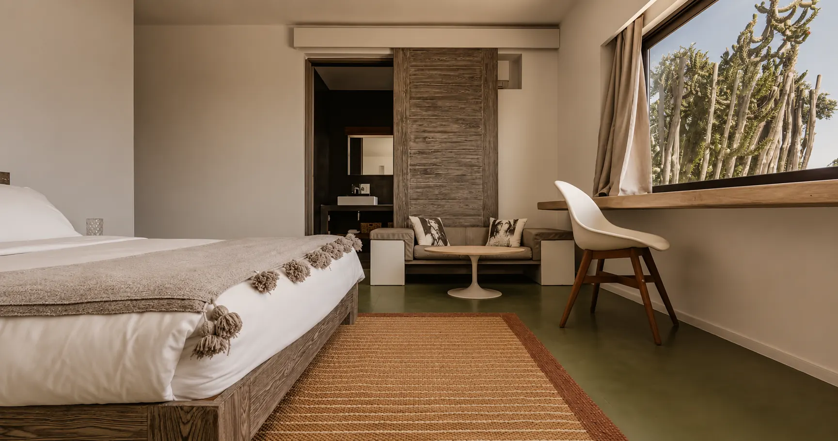Suite parentale de la Villa Nausikaa et sa salle de bain attenante derrière une porte coulissante en bois