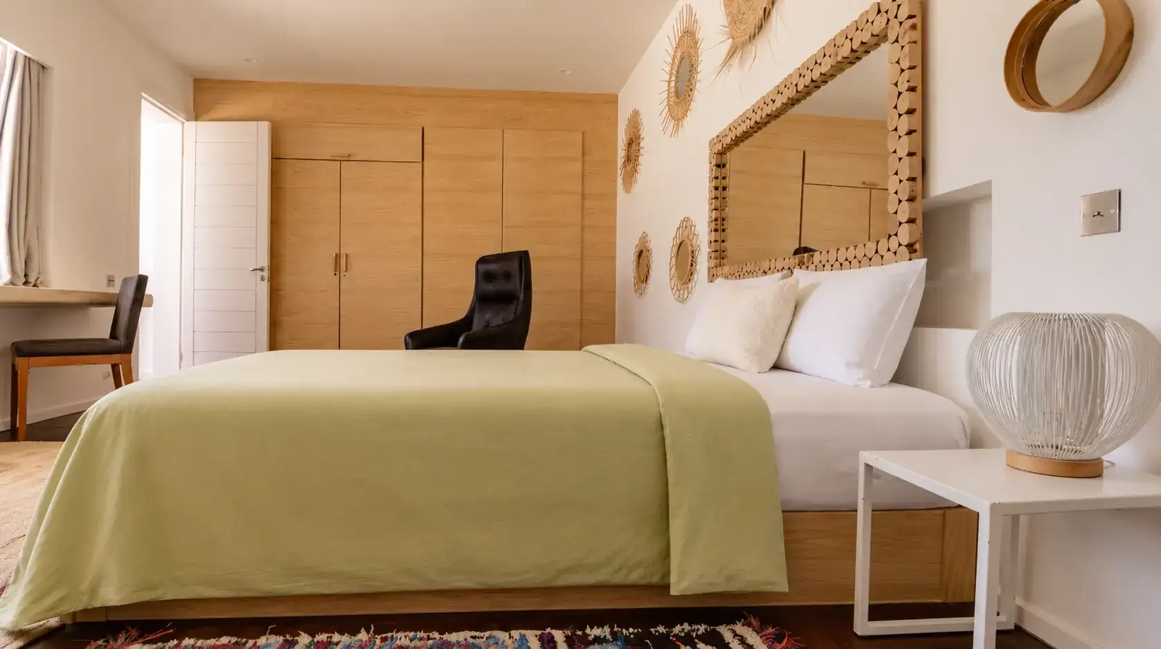 Chambre II de la Villa Nausikaa : mur de placards en chêne et fauteuil en cuir