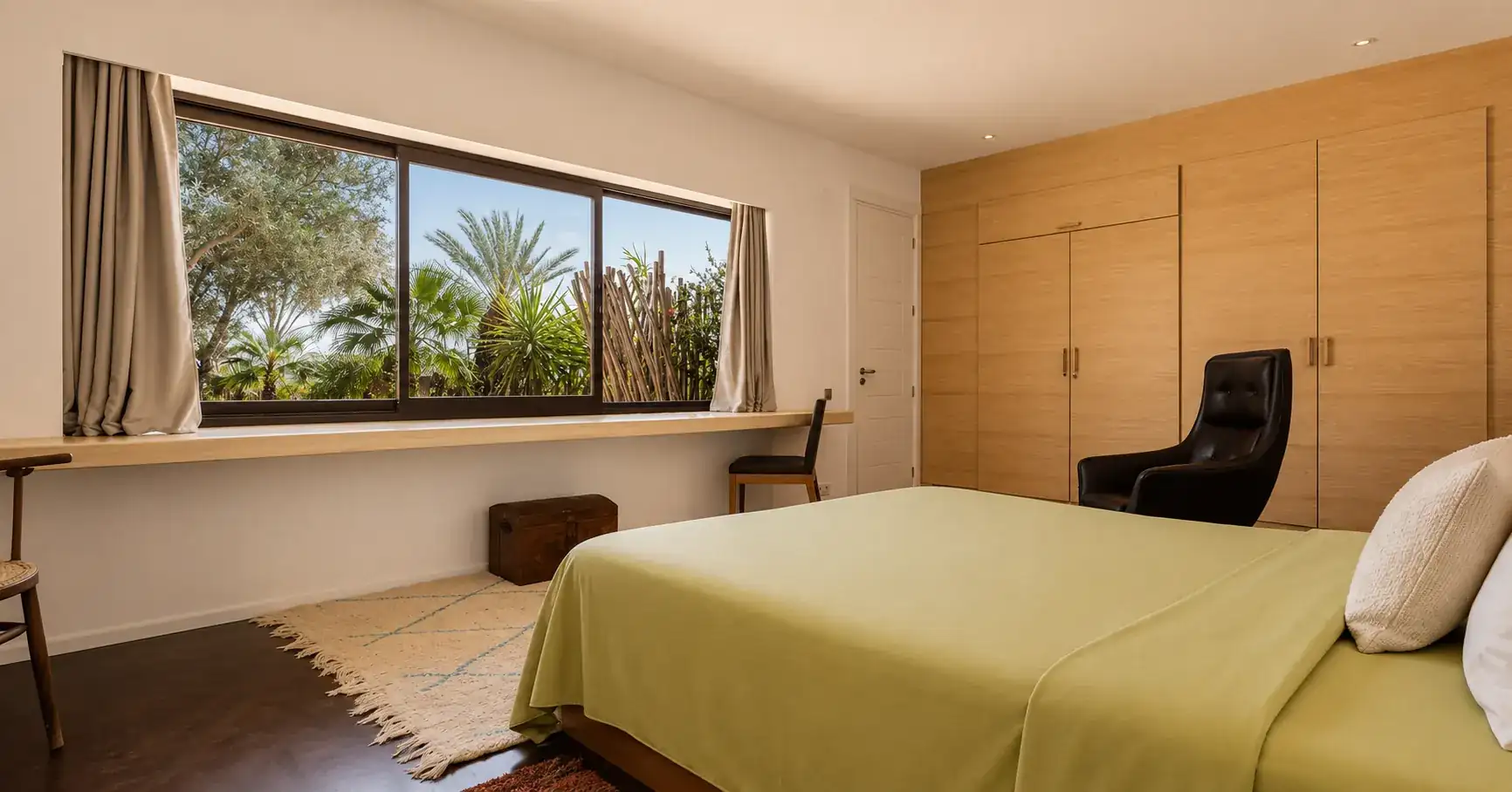 Chambre II de la Villa Nausikaa ouverte sur les oliviers et les palmiers du jardin