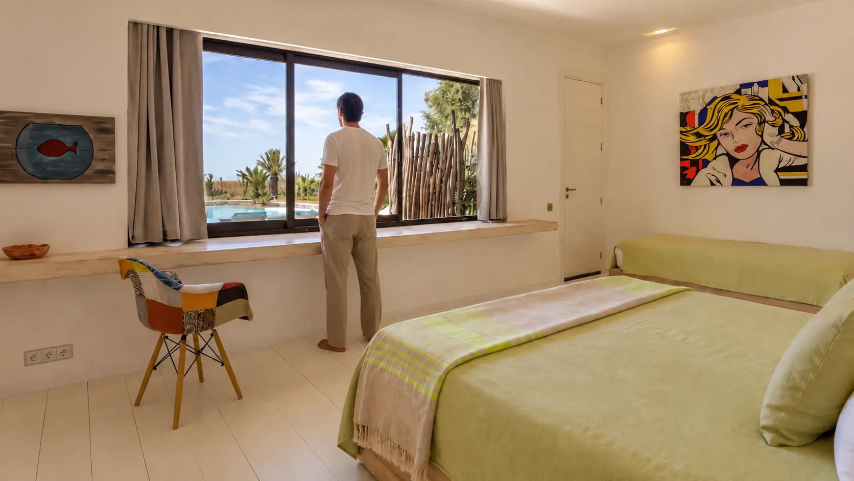 Chambre III de la Villa Nausikaa : fenêtre panoramique sur la piscine et toile pop art