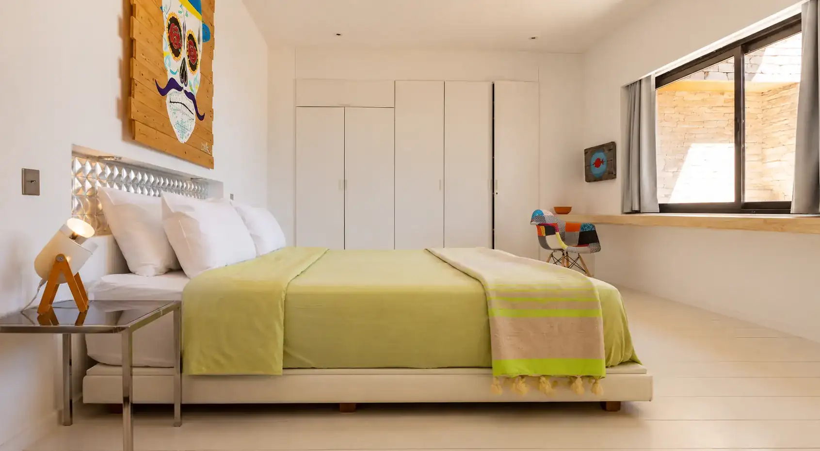 Chambre III de la Villa Nausikaa : placards intégrés, bureau sous la fenêtre et fauteuil Eames