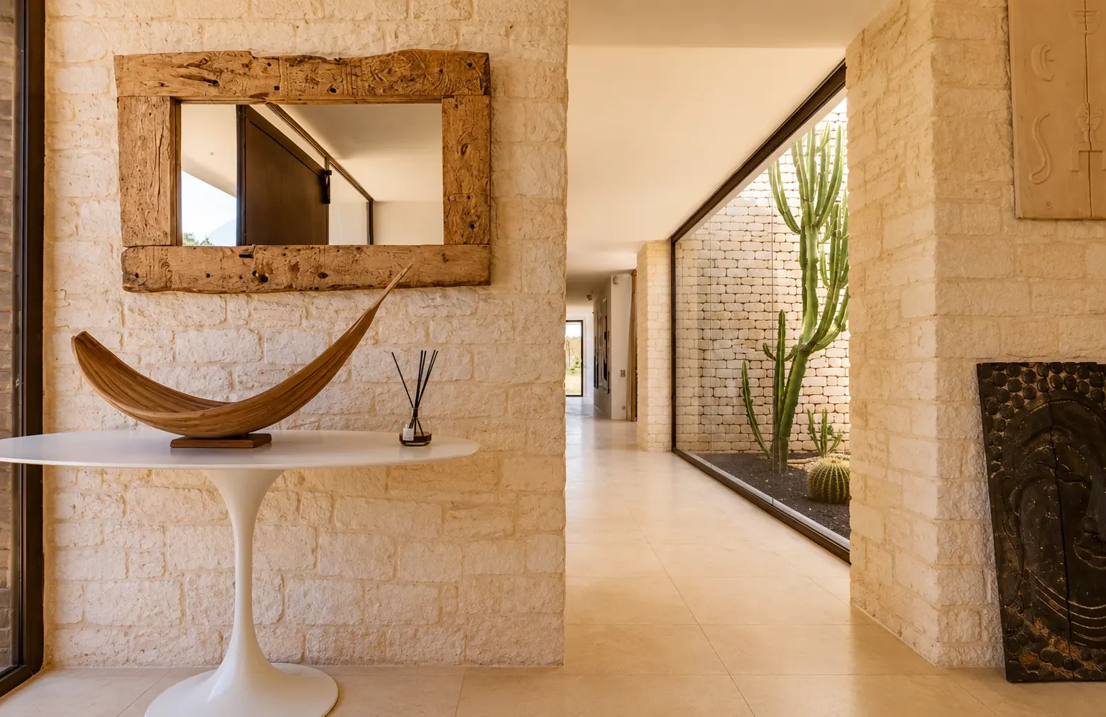 Miroir en bois flotté et console Tulip dans l'entrée de la Villa Nausikaa, à Essaouira