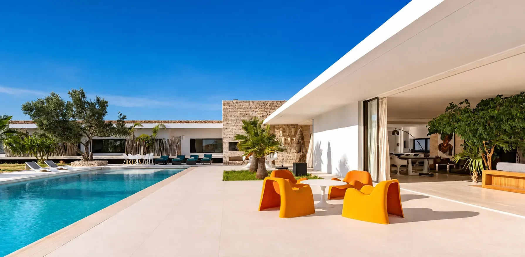 Vue panoramique de la Villa Nausikaa : piscine de 20 mètres, terrasse couverte et séjour ouvert