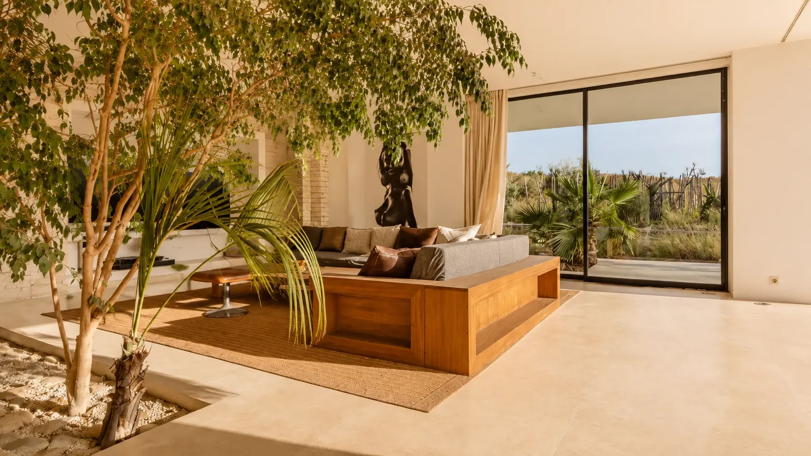Ficus géant et patio de galets dans le salon de la Villa Nausikaa à Essaouira