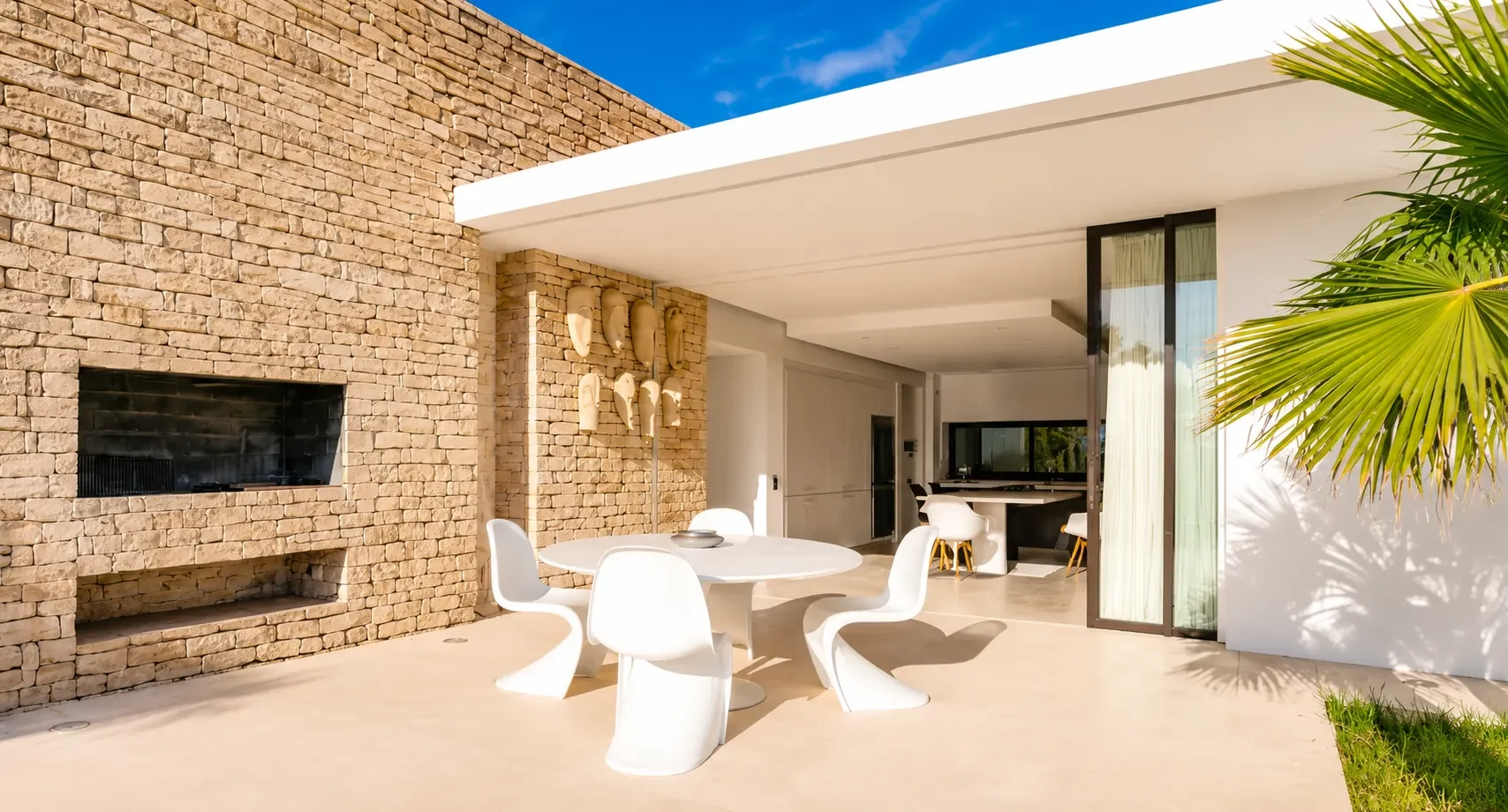 Terrasse couverte et barbecue maçonné en pierre de la Villa Nausikaa, ouverte sur la cuisine