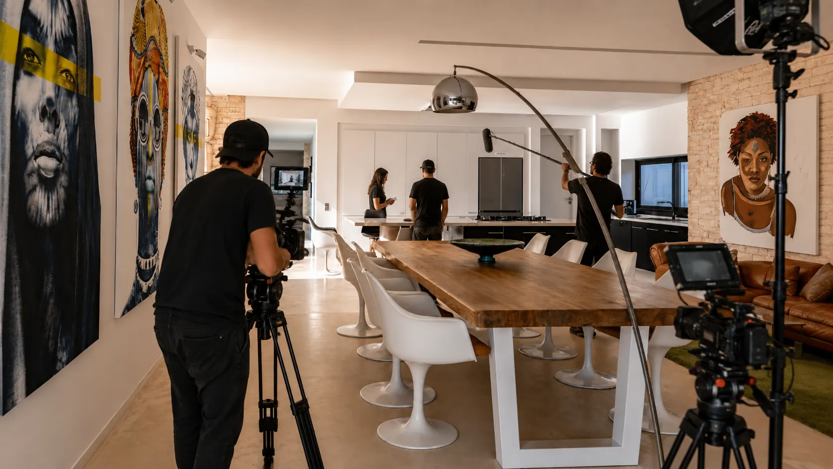 Équipe de tournage en place dans la salle à manger de la Villa Nausikaa : caméra sur trépied, perche son et éclairages